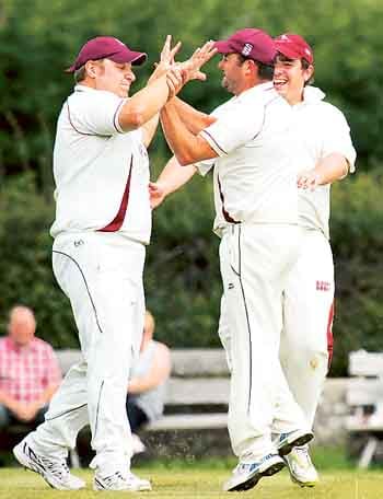Rhydian Rees is congratulated by Matthew Lewis and Scott Arthur after taking the catch to dismiss Simon Holliday.