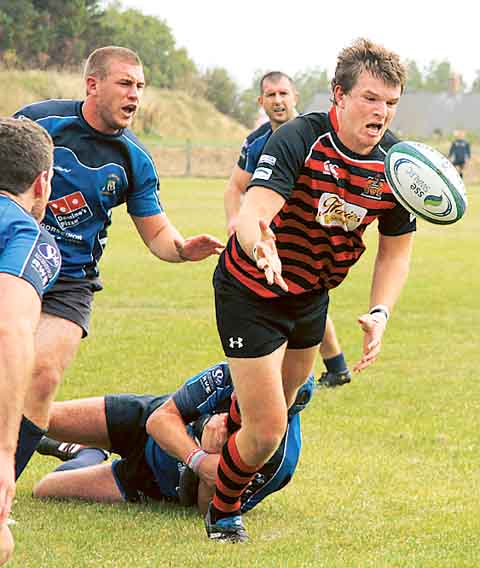United centre Toby Smith offloads the ball under extreme pressure.