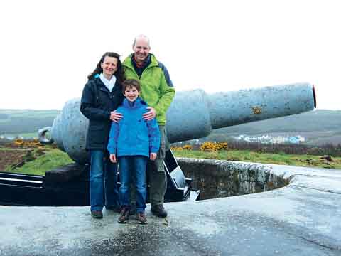 Chapel Bay Fort and Museum’s first visitors, Samantha and Jonathan Warr and their nine-year-old son Barnaby from Cambridge, are pictured alongside the biggest gun in Wales - a 10-inch 18 tonne mark II rifled muzzle loader dating from the 1860s and 1870s and designed for a battleship. Pic. Chapel Bay Fort and Museum.