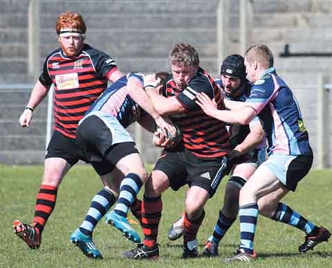 It takes three Ammanford players to stop Wyndham Williams. Pic. Susan McKehon
