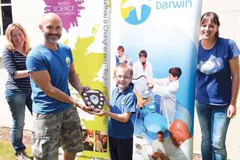 A representative of Sageston School receives the Welston Challenge shield from Darwin Centre director, Marten Lewis.