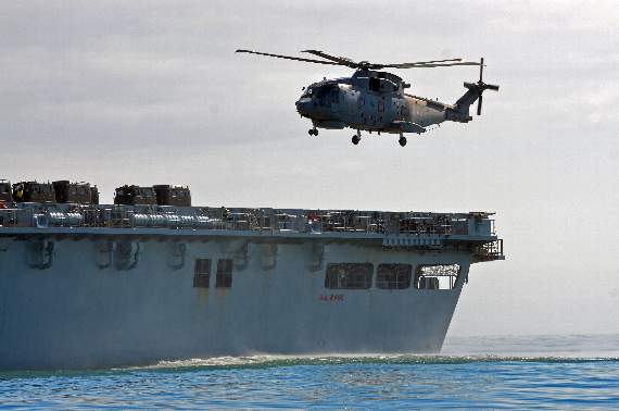 An anti-submarine warfare Merlin helicopter lands on HMS Bulwark’s flight deck stationed five miles off Tenby as part of the exercise.