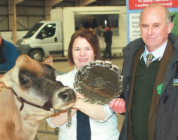 Jenny Jenkins, on behalf of the owners, Huw and Jennifer Evans, receives the award for the champion cow from president Brian Bowman.