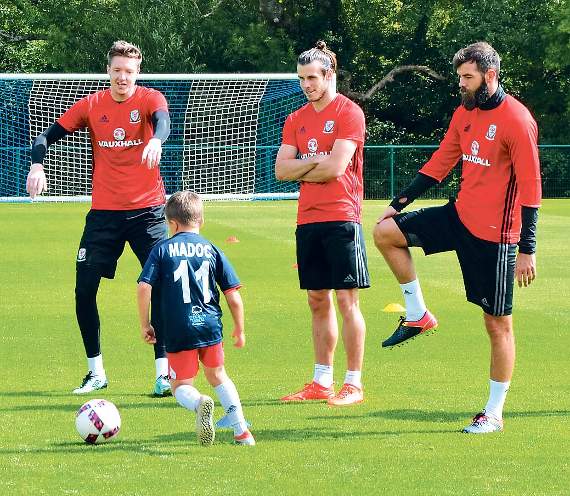 Madoc, who plays for Tenby AFC U8s, is seen demonstrating his skills to Hennessey, Bale and Ledley.