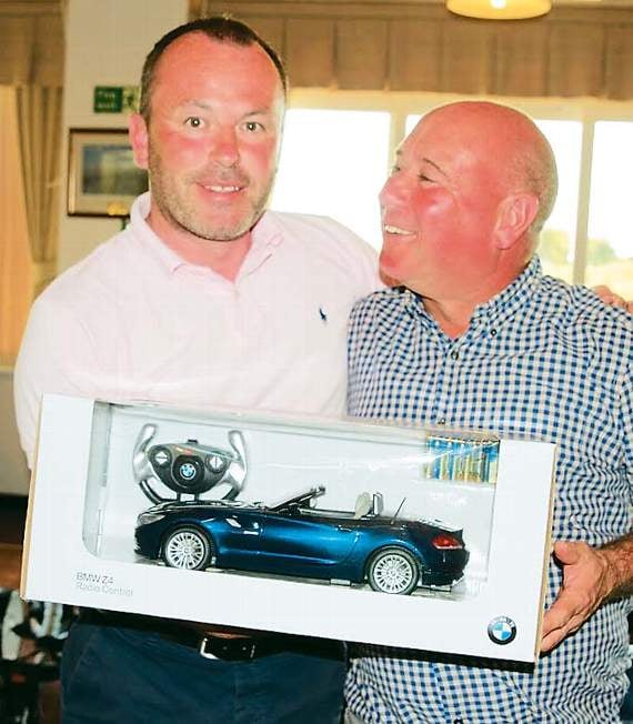 Philip Turner (left), sales manager at Sytner Haverfordwest (hole-in-one sponsors), with Neal Evans, of Glynhir, and the remote-controlled BMW car he won.