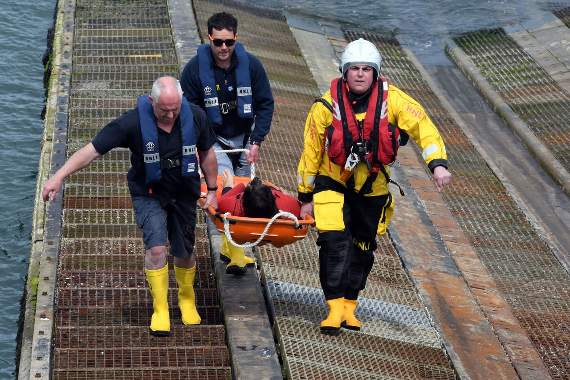 A mock exercise showing a ‘tombstoning’ participant brought ashore