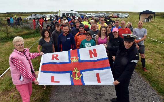 Mike Brotherton, retired naval chaplain and deputy launching authority of Angle Lifeboat Station, with great appreciation and ‘humour’ started the walkers and runners on the four or eight-mile course. He is seen at the start with RNLI Guild chairman Daphne Bush.