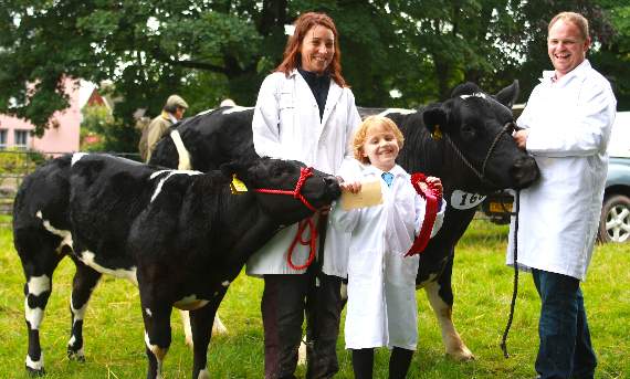 Mark Williams and his daughter, Izzie, assisted by Kat Watkins show off their prize-winning British Blue cow, the second calver Ffynnon Henrietta with Millie, her April-born calf.