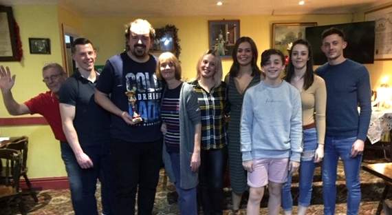Winner of the darts tournament Ben Farr with the Evans family.