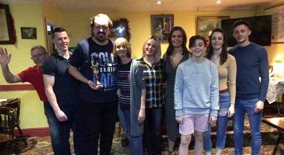 Winner of the darts tournament Ben Farr with the Evans family.