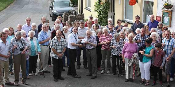 PRESENTATION: Brian is presented with his Leavers Award from the Post Office's Neil Jenkins with the residents of Linton.