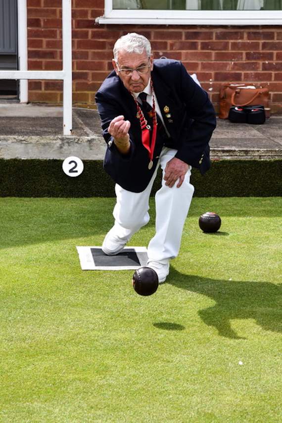 Club president Roland Bath helps officially open the outdoor bowling season.