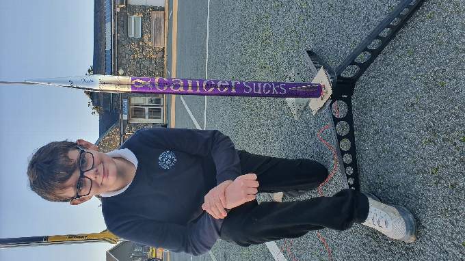 Logan is pictured with the rocket he made