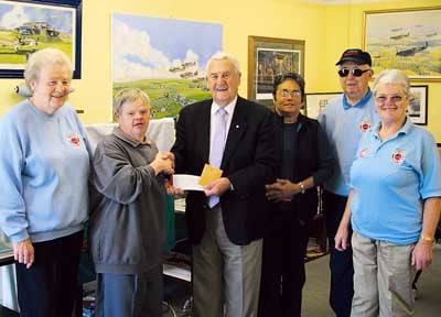 Fundraising swimmer James Merriman is pictured giving a donation to John Brock, of Carew Control Tower.