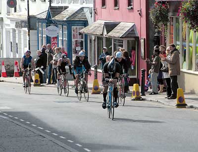 Clapped on by spectators, cyclists make their way through Narberth’s High Street on the bike leg of Sunday’s Ironman Wales event. Pic. Ieuan Williams