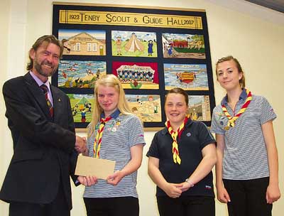 From left, Rotarian Andy Tulley, president of the Rotary Club of Tenby, is pictured presenting a cheque to Tenby Guides’ Harriet Sleight, Bethan Griffiths and Hayley Richards.