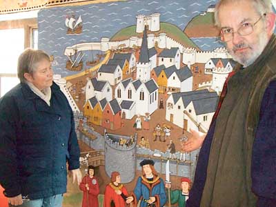 Dr. Charles Kightly and custodian Alyson Bush alongside one of the painted cloths.