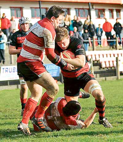 Luke Dedman crashes over for a try, despite the attentions of two Emlyn defenders.
