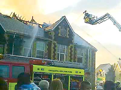 Flashback to Sept-ember 2009: Onlookers stand and watch as firefighters tackle the blaze which destroyed the building.