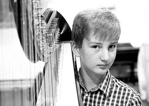 Tudor Hurle playing the harp.