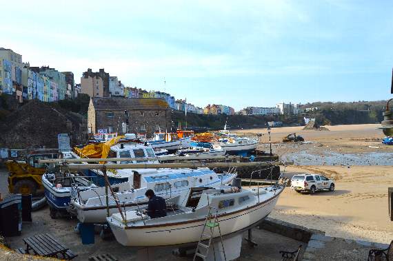 A lone worker preparing one of the boats at Tenby harbour on Monday for the planned operation to return vessels into the water which has now been postponed (Observer pic)