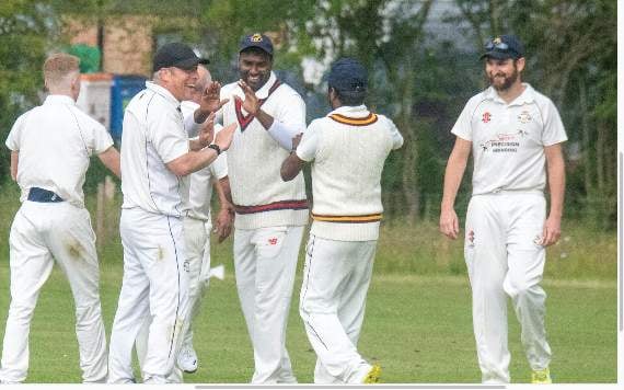Balasingham Sivathas is congratulated after taking a catch.