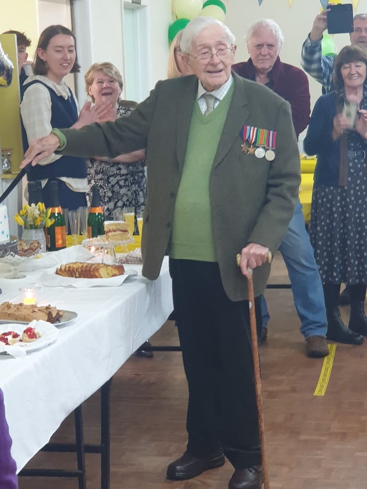 John Gwynne cuts his 101st birthday cake, surrounded by family and friends