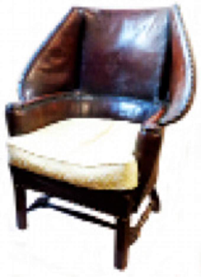 An early 20th Century barrel back armchair with bow frame and studded leather upholstery, set on a mahogany turned stretcher base with square supports. Sold for £780.