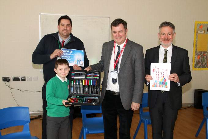 Newton St Cyres Primary School pupil Zak Harris (8) receiving his prize from local MP Mel Stride for coming runner-up in his 2021 Christmas Card Competition, pictured with Executive Headteacher John Jolliffe, right, and Head of School James Durward-Akhurst. AQ 5023