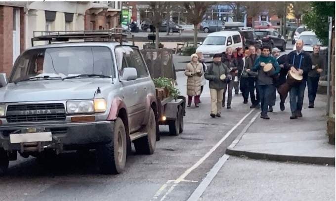 The car and trailer carrying the fragments of the benches made its way to Crediton Library accompanied by people playing drums and carrying lanterns. NP 160122 05