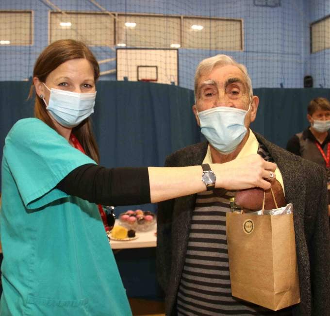 Crediton County Councillor Frank Letch received a gift for helping steward at the Vaccination Centre from Dr Jo Harris. AQ 4947