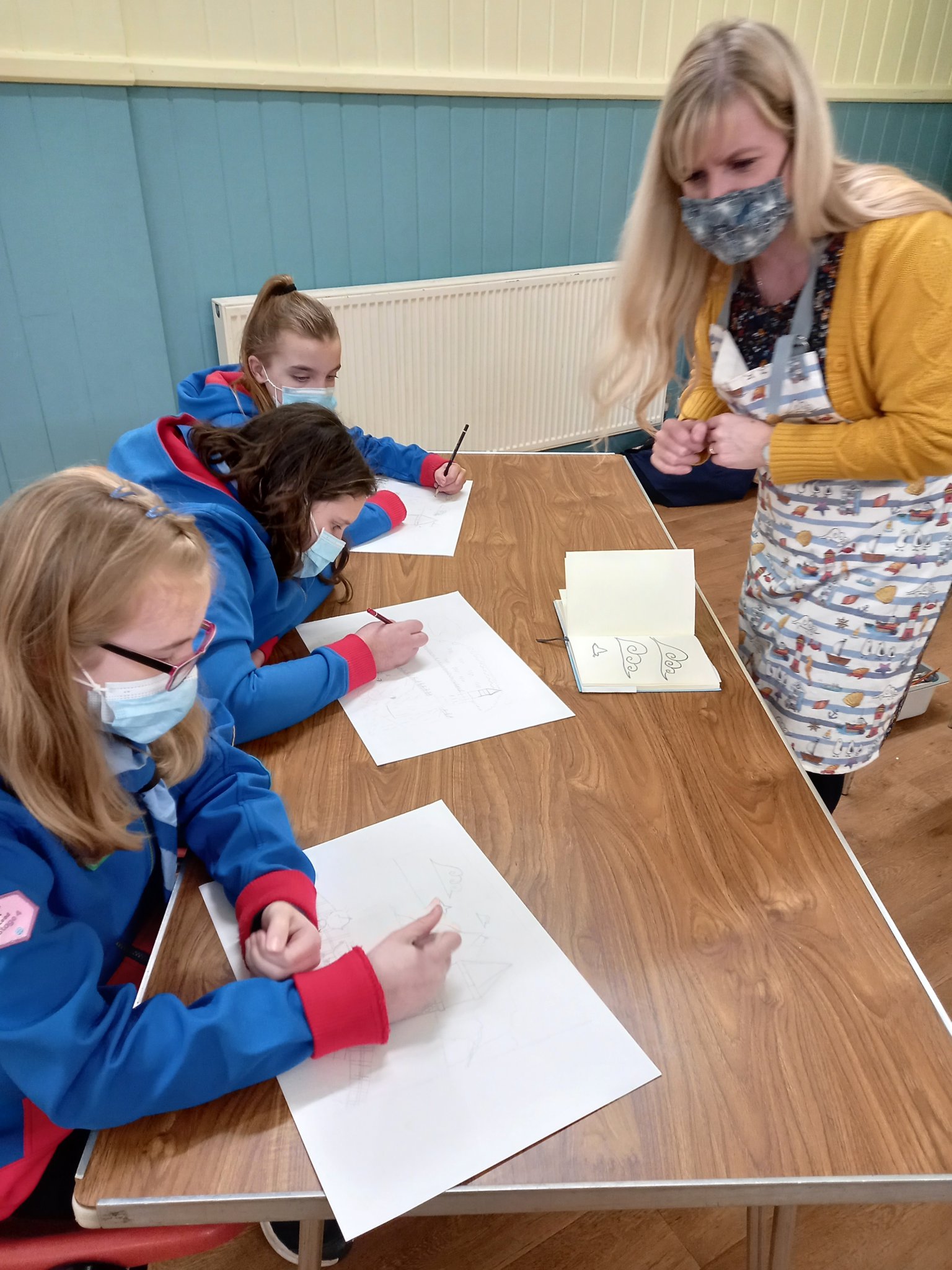 ARTIST AT WORK: Laura Wall demonstrating how to draw and paint the lighthouse and Ness to the Guides.
Picture: 1st Teignmouth Guides (Feb 2022)