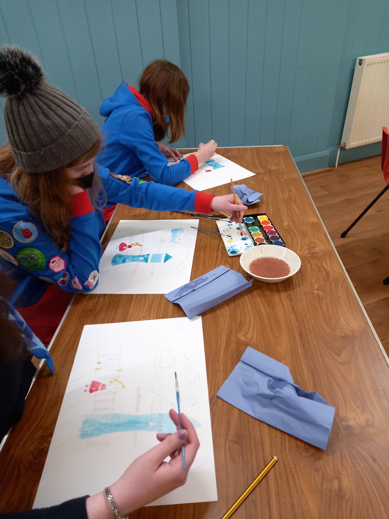 ARTIST AT WORK: Laura Wall demonstrating how to draw and paint the lighthouse and Ness to the Guides.
Picture: 1st Teignmouth Guides (Feb 2022)