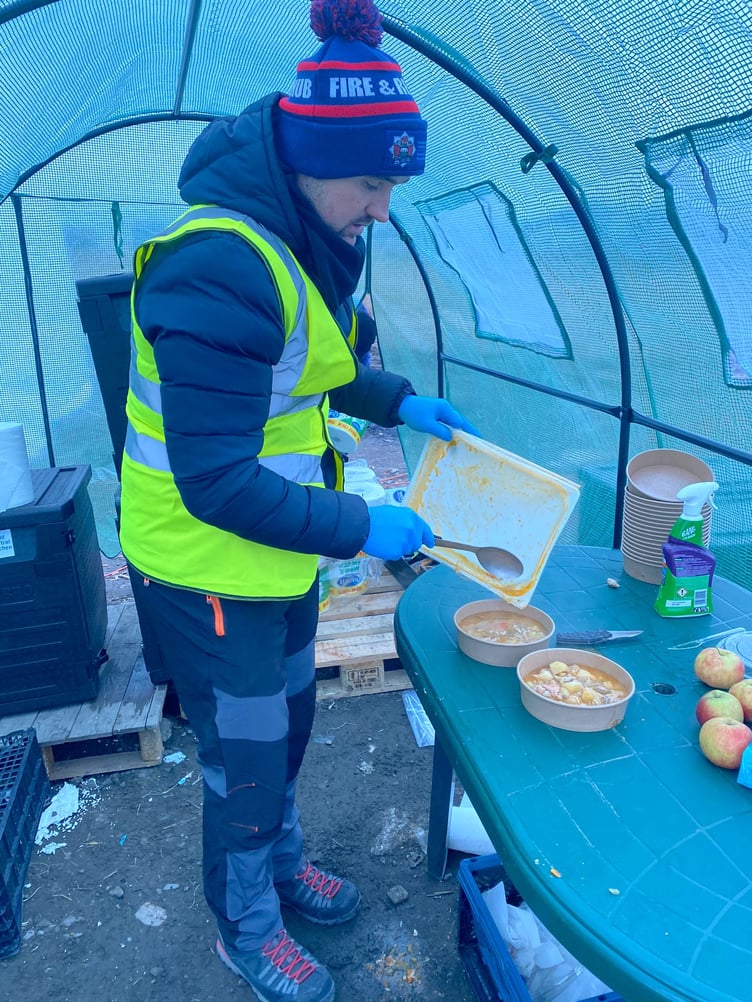Nathan serving hot food for refugees
