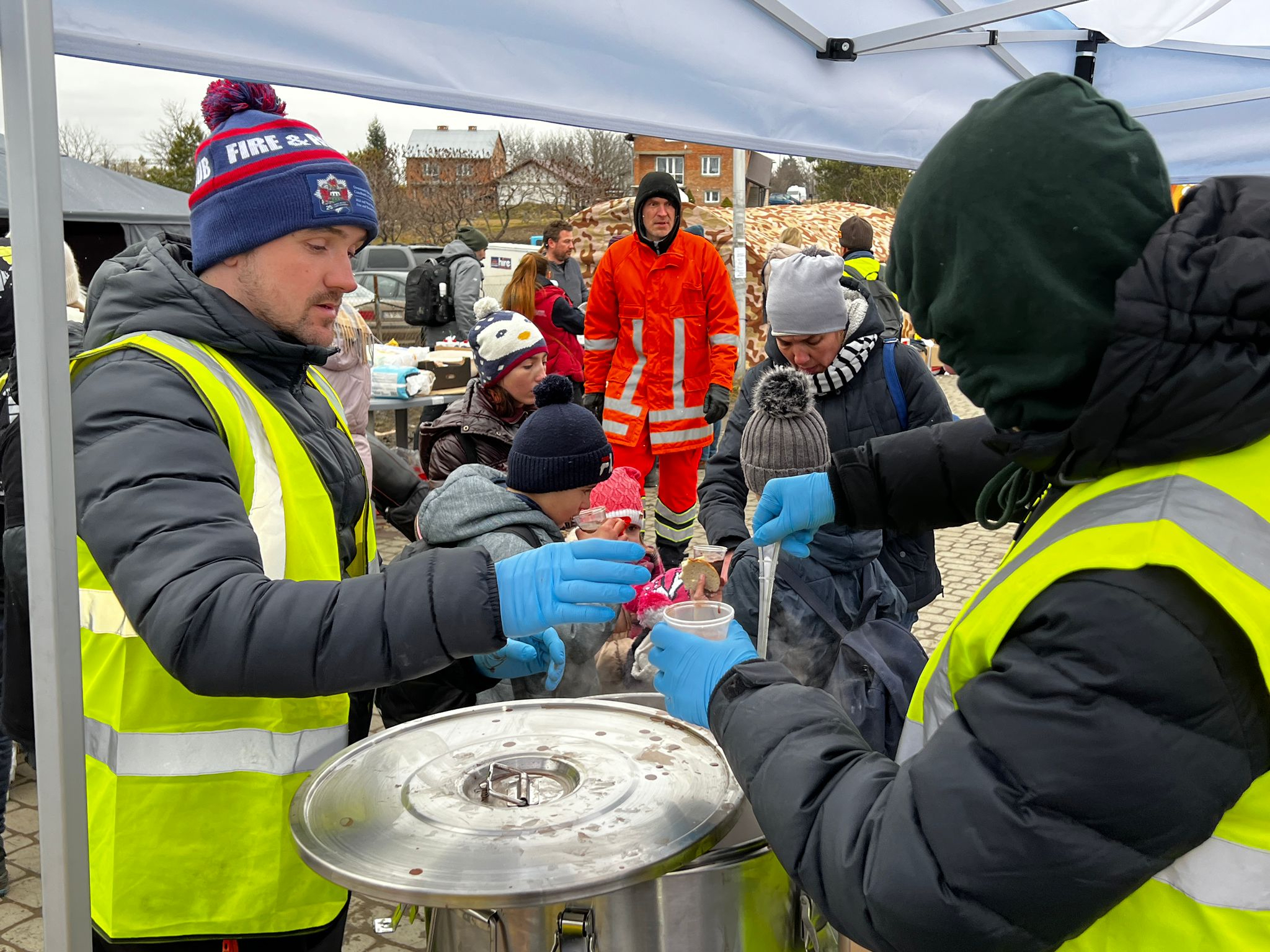 Serving a hot chicken and potato dish to refugees