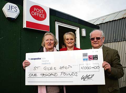 NEW BOOST FOR ST GILES SHOP FUND: This cheque for £1,000 was presented to the St Giles-on-the-Heath community shop fund by local Torridge District Councillor Marion Perkin — half of her members’ allowance. From left are: Marion Perkin, Jeanette Hendrie (who runs the shop) and Ken Hamlyn the chairman of the community shop group.