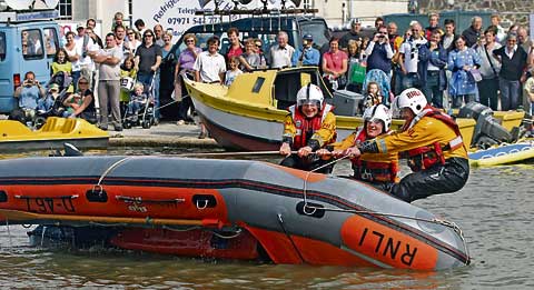 CAPSIZE ON THE CANAL: Bude RNLI members Sam Jordain, Andy Cloke and Dave Monkton — on the canal — show the crowd what they do if a vessel capsizes.