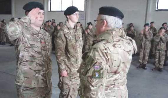 Saluting, Corporal James Britt receiving his promotion to Sergeant alongside Jack Heal at the recent training camp