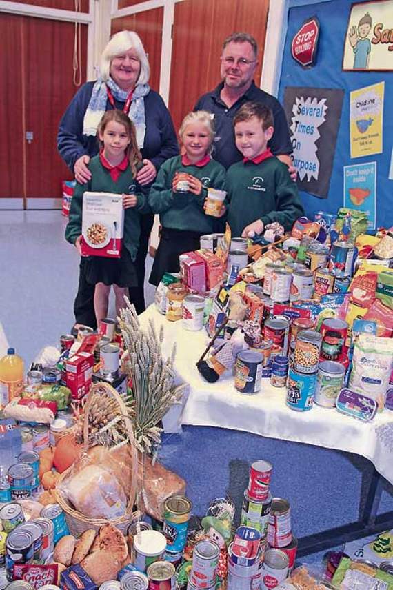 With Bude Junior pupils are Sue Jarvis from Bude Foodbank and caretaker Simon Hodge, who kindly helped set up the display. Picture: Paul Hamlyn