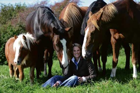 Emma surrounded by a number of horses.
