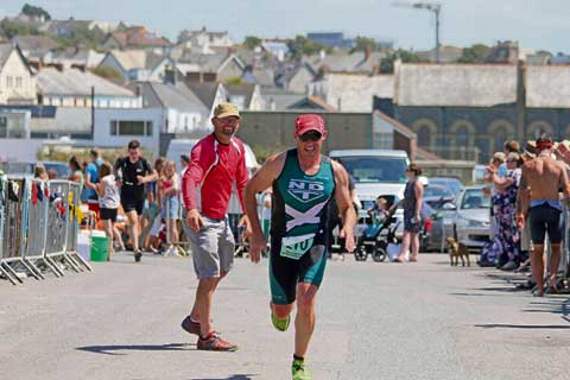 Bude’s James Marshall, who finished 13th out of over 200 entries, is encouraged towards the finish line by race organiser and owner of Shoreline Extreme Sports, Simon Hammond. Picture: Paul Hamlyn
