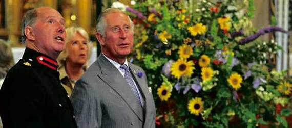 Standing in front of one of the magnificent flower displays, Blisland resident Major Charles Edward Collins, escorting the Royal couple on their visit, points out ancient features of Blisland Church.