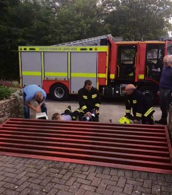 The crew used hydraulic lifting equipment to raise the cattle grid so one crew member could reach down and retrieve the trapped animal.