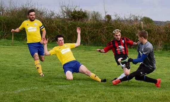 St Breward forward Nathan Jasper (red) looks to get to the ball as goalkeeper Corrie Crook comes out to thwart him during their 5-2 victory over St Minver Reserves in Division Two of the JJ Jones and Sons Duchy League at Brake Parc last Thursday night. Picture: Adrian Jasper