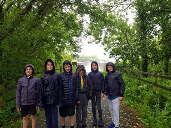 The Scouts braved the wet weather to install dog waste bag dispensers around the town, made from empty plastic bottles.
