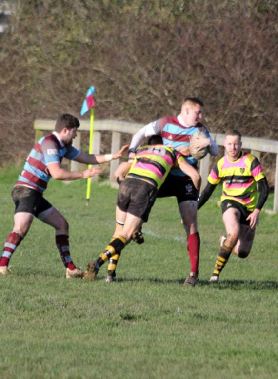 Bude winger Ryan Butler, who scored a hat-trick, is tackled by full-back Will Lethbridge.