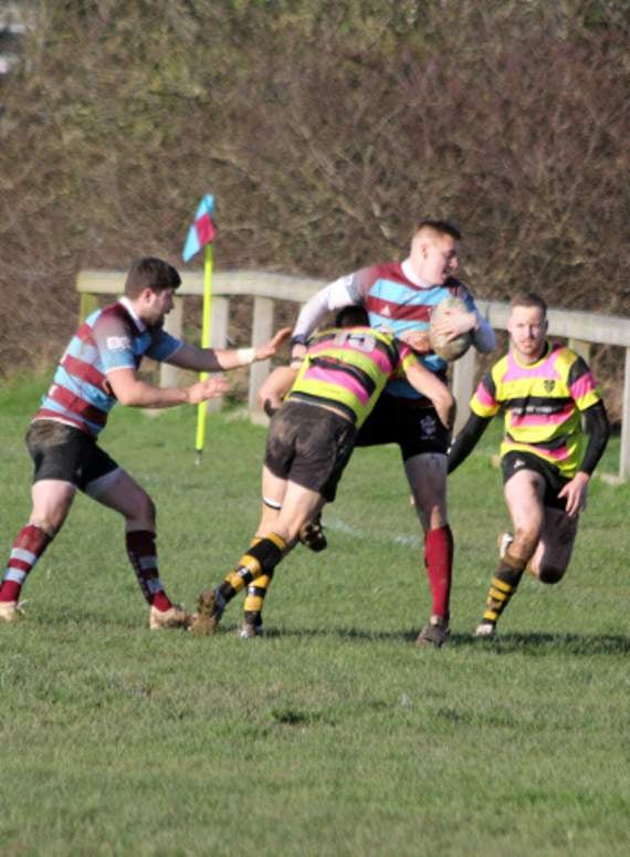 Bude winger Ryan Butler, who scored a hat-trick, is tackled by full-back Will Lethbridge.