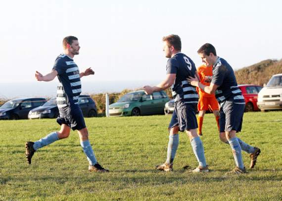 Boscastle’s Jack Gibson (left) and Matt Jolliffe (right) celebrate one of Johnny Strout’s four goals against Grampound on Saturday. Picture: David Flower