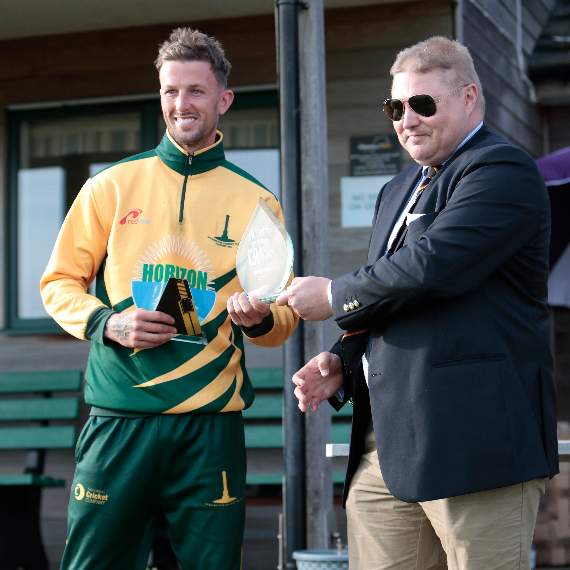 Joe White being presented the trophy by Cornwall Cricket League vice-chairman Stuart Wilder.