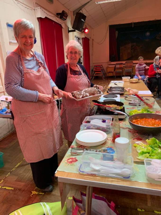 Cooks, Pat Mallett, on the left, and Alison Gribble, on the right, showcasing the delicious food that they had prepared, prior to the much anticipated tasting